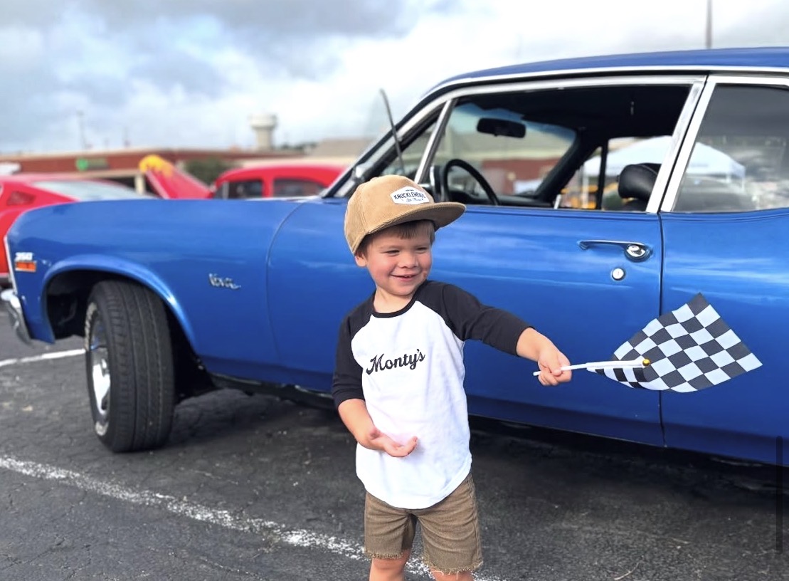 Young Monty's fan at a car show wearing branded shirt