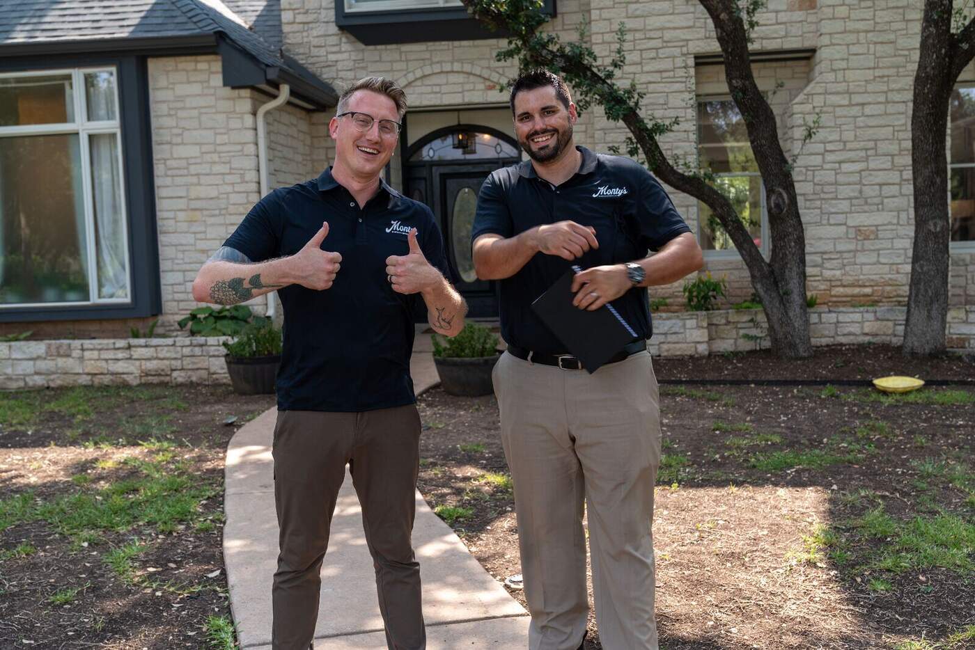 Two Monty's handyman team members giving thumbs up after completing a home repair