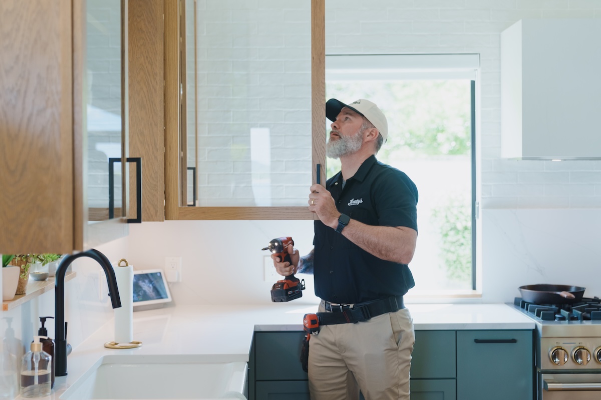 Monty's technician handling cabinet adjustments during a kitchen upgrade